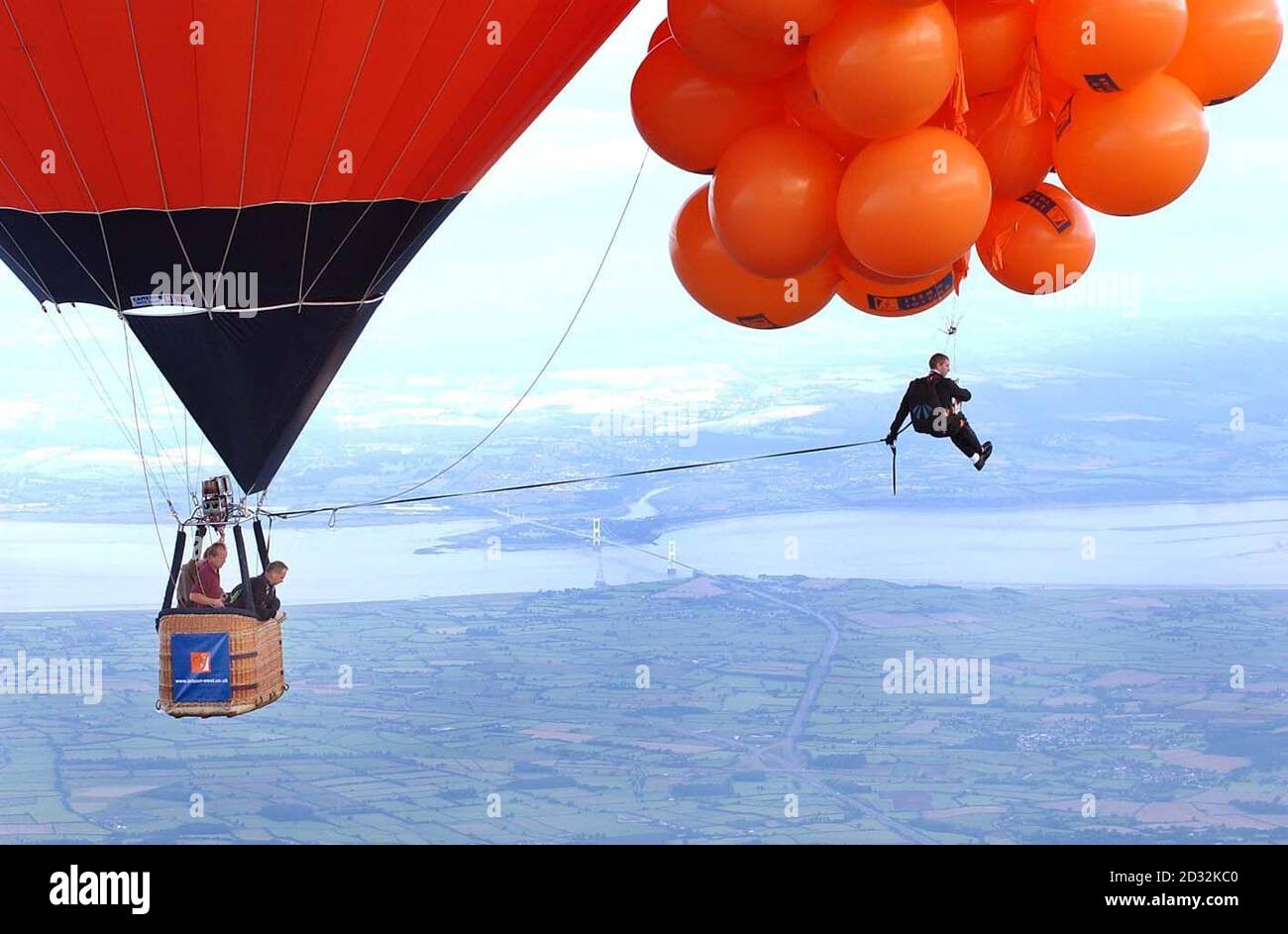 Mike Howard dangeant sous des centaines de ballons remplis d'hélium à la Bristol Balloon Fiesta. Howard, habillé comme son héros du diable dans une veste de dîner, s'est élevé à plus de 7 000 pieds mais n'a pas réussi à monter suffisamment haut pour battre le record mondial de 11 000 pieds en raison de la couverture de nuages lourds. Banque D'Images