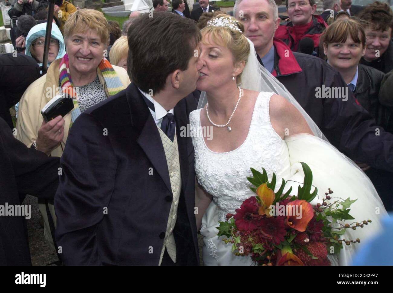 Le chanteur de pays irlandais Daniel O'Donnell embrasse sa mariée, Majella McLennan, à l'extérieur de l'église St Mary's après qu'ils se soient mariés, à Kincasslagh, Co. Donegal. Quelque 550 personnes, dont des amis, de la famille et des voisins, ont assisté au mariage traditionnel. * ... à l'église sur le bord de l'eau en Irlande de l'Ouest que les foules de fans ont cherché à féliciter le couple. Banque D'Images