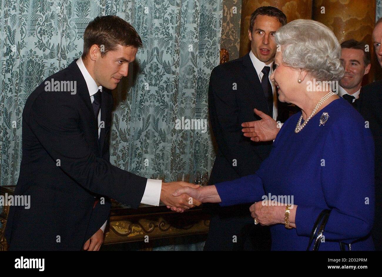 La reine Elizabeth II britannique, l'attaquant de l'Angleterre Michael Owen, tandis que Gareth Southgate, (2e gauche), l'ancien chef de l'exécutif de la FA Adam Crozier (2e droite) et le directeur exécutif de la FA David Davies, attendent d'être présenté, *... pendant une réception pour l'Association de football qui s'est tenue au Palais de Buckingham. La fête d'Angleterre, forte de 75 personnes, comprend le personnel de l'arrière-salle ainsi que des joueurs et des dirigeants de haut niveau, est arrivée au Palais en trois entraîneurs. La réception de boissons et de canapés a été organisée dans la salle de dessin bleue du Palais où le président de la FA, Geoffrey Thompson, ainsi que l'entraîneur et le capitaine de l'Angleterre, ont été couronnés Banque D'Images
