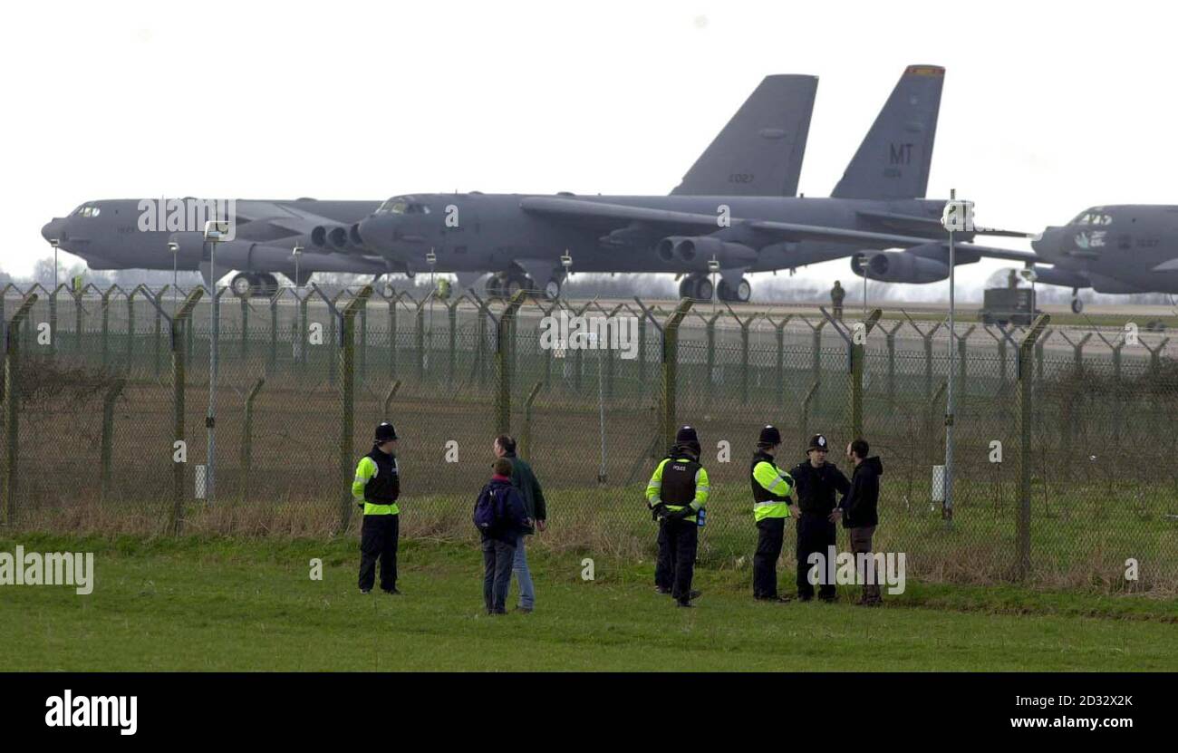 B52 aircaft au loin tandis que la police parle avec les visiteurs de la  clôture périphérique de la base aérienne américaine à RAF Fairford,  Gloucestershire. Douze personnes ont été arrêtées à la