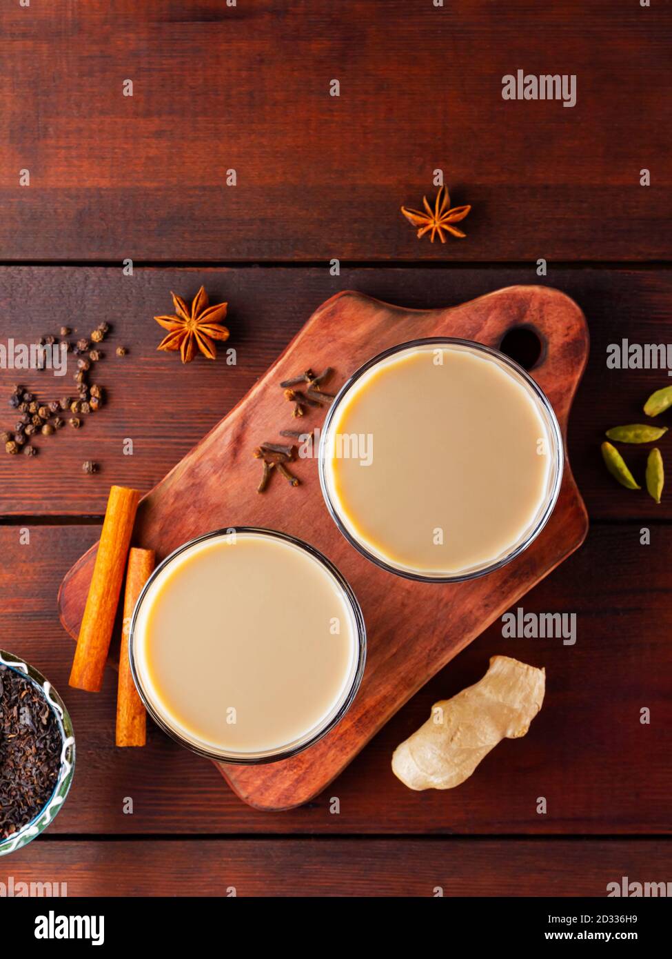 Thé au lait et épices. Thé Chai au masala sur des planches en bois. Deux verres de thé masala et des ingrédients pour le préparer. Copier l'espace. Vue de dessus Banque D'Images