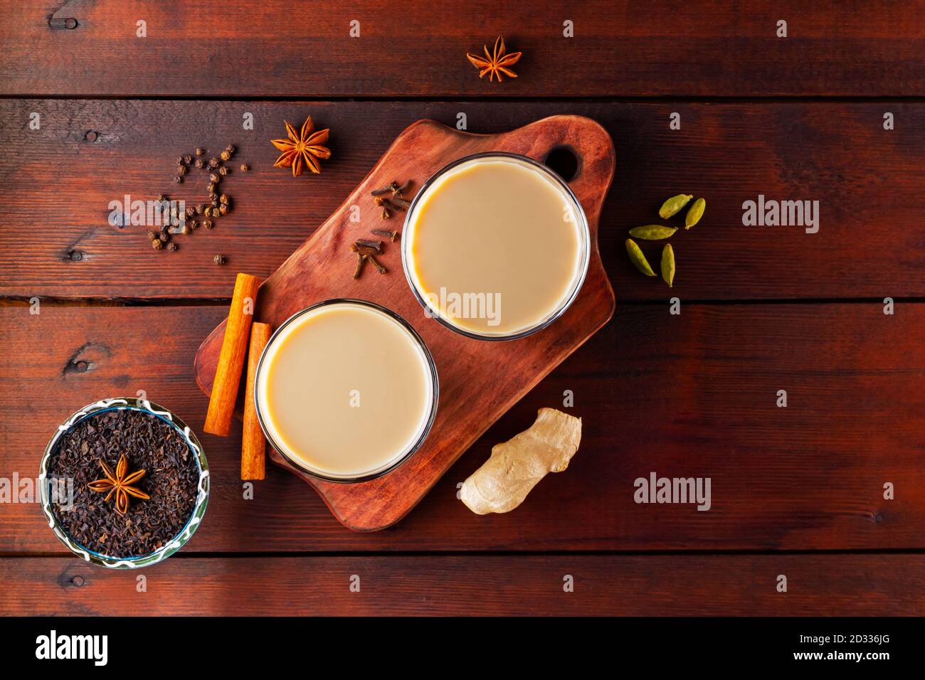 Thé au lait et épices. Thé Chai au masala sur des planches en bois. Deux verres de thé masala et des ingrédients pour le préparer. Copier l'espace. Vue de dessus Banque D'Images