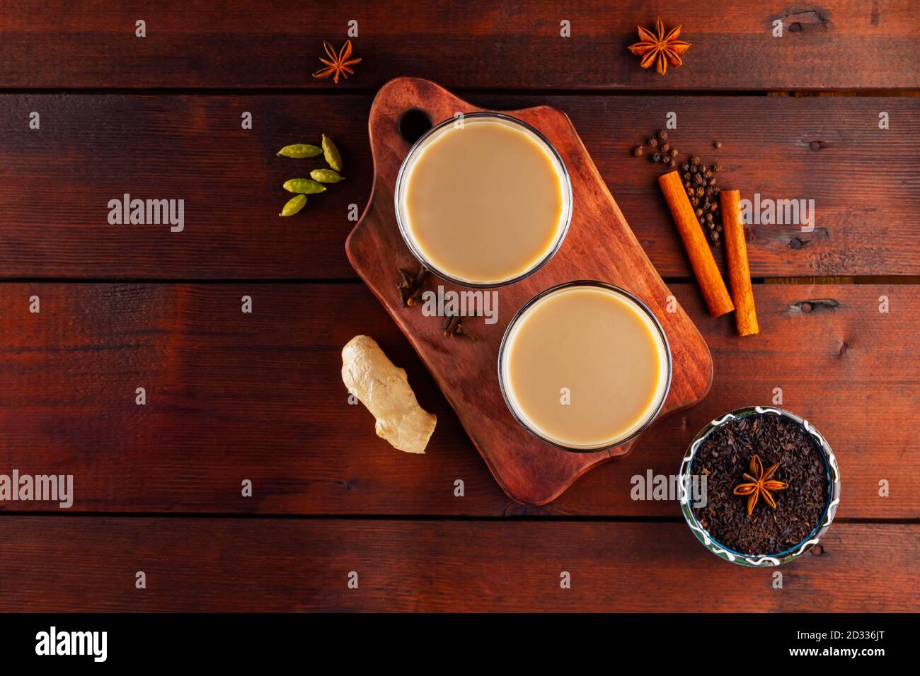 Thé au lait et épices. Thé Chai au masala sur des planches en bois. Deux verres de thé masala et des ingrédients pour le préparer. Copier l'espace. Vue de dessus Banque D'Images