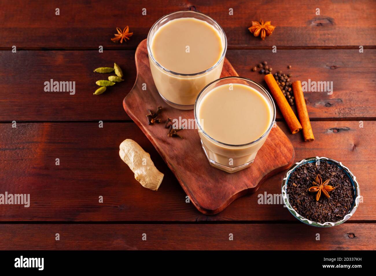 Thé au lait et épices. Thé Chai au masala sur des planches en bois. Deux verres de thé masala et des ingrédients pour le préparer. Copier l'espace. Vue de dessus Banque D'Images