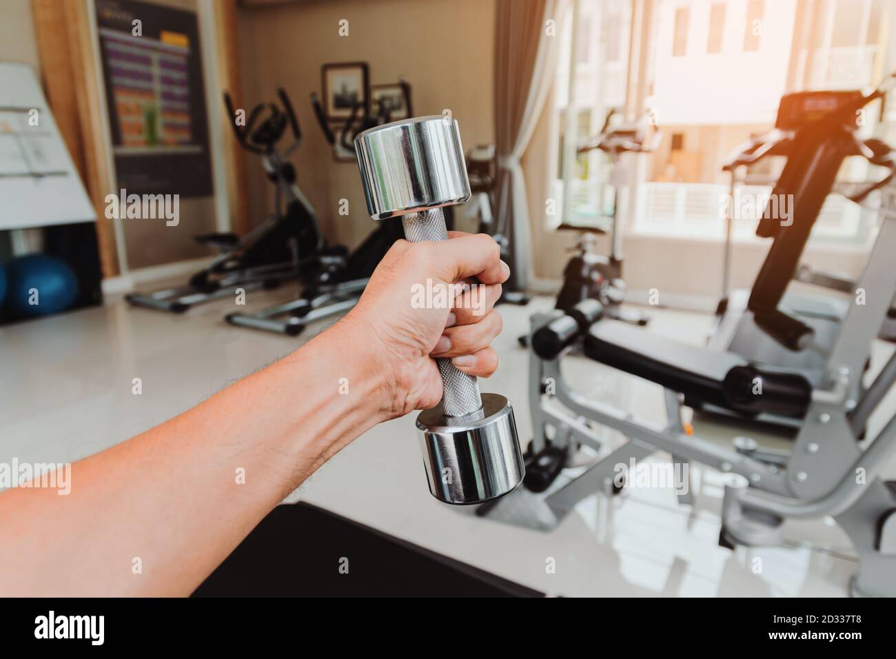 Gros plan la main d'un homme tient une haltère avec sa main gauche dans la salle de gym, concept pour l'exercice et les soins de santé. Banque D'Images Gros plan la main d'un homme tient une haltère avec sa main gauche dans la salle de gym, concept pour l'exercice et les soins de santé. Banque D'Images