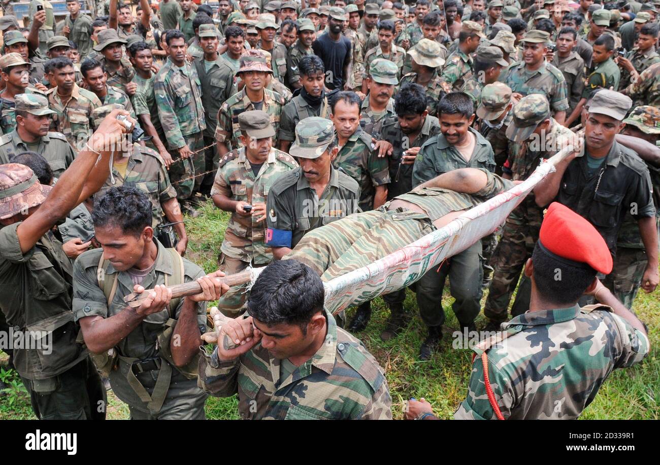 The body of Liberation Tigers of Tamil Eelam (LTTE) leader Vellupillai  Prabhakaran is carried on a stretcher through a group of Sri Lankan  soldiers at Nanthikadal lagoon, near the town of Mullaittivu