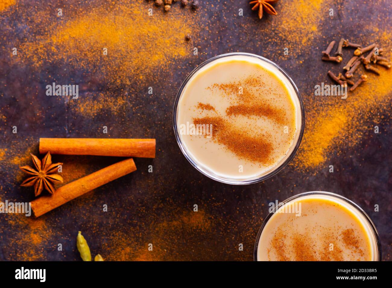 Thé Chai de masala sur fond noir. Deux verres transparents de thé masala et diverses épices éparpillées. Vue de dessus Banque D'Images
