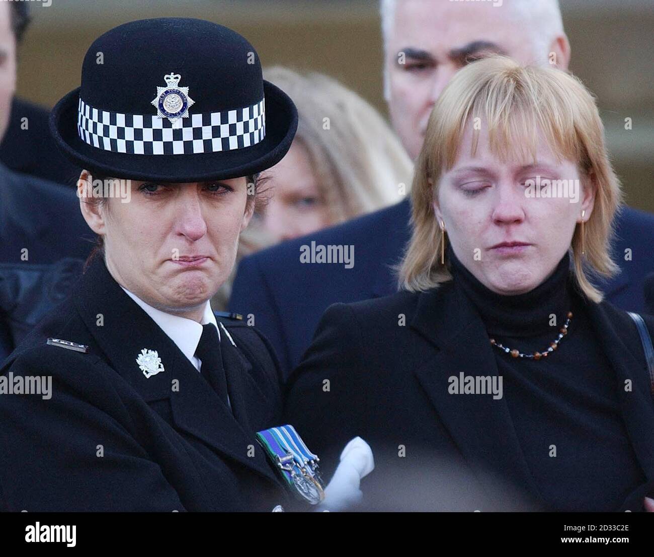 La veuve du policier de la circulation Ian Broadhurst, Eilisa (à droite), est aux côtés des officiers, à l'église de la paroisse de Leeds, dans le West Yorkshire, alors que des centaines de boureurs se sont joints pour faire un dernier adieu à son mari. Le PC Broadhurst, 34 ans, de Birkershaw, dans le West Yorkshire, a été tiré deux fois tout en aidant à arrêter l'américain David Bieber à Dib Lane, Leeds, le lendemain de Noël 2003.les funérailles ont commencé avec environ 800 personnes emballées dans l'église et des centaines d'autres dehors regardant la cérémonie sur un grand écran vidéo. Banque D'Images