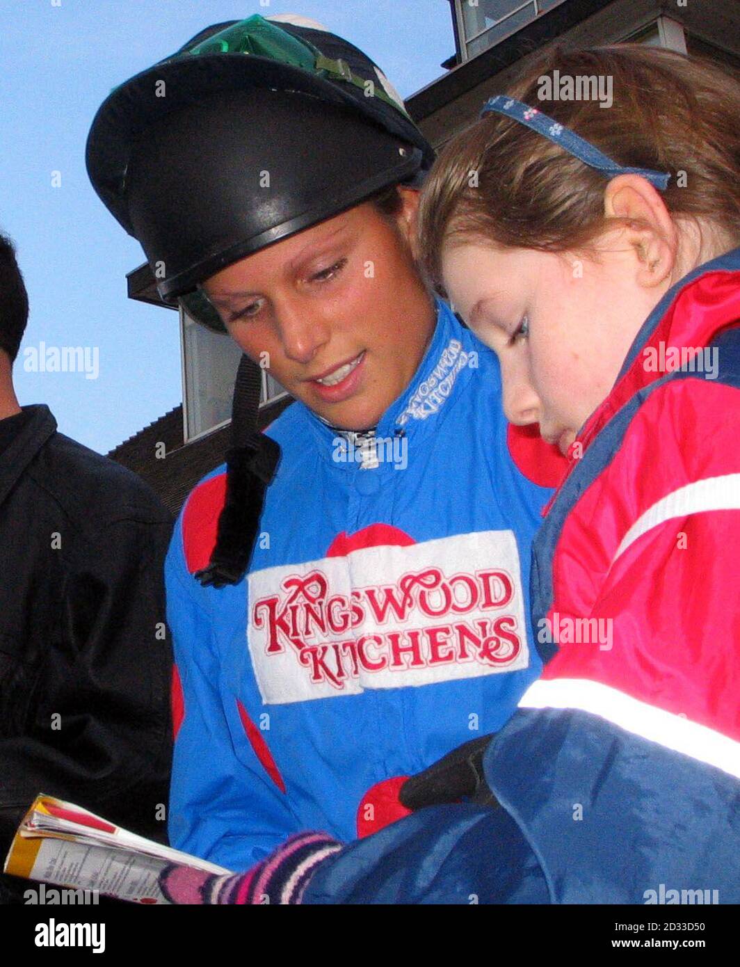 Zara Phillips autographe une carte de course pour une jeune femme, avant de terminer sur les trois premiers sur son mont, Mme Phillips, dans la Reine mère Memorial Fund Charity Flat Race, à Newbury. Banque D'Images