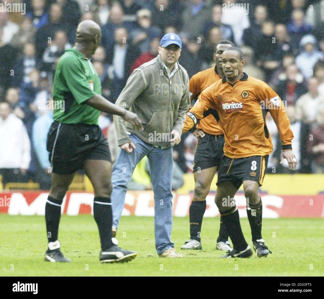 Un fan de Wolverhampton Wanderers (au centre) est tenu loin par Paul Ince de l'arbitre Uriah Rennie (à gauche) après que Bolton Wanderers ait marqué le but gagnant, pendant le match Barclaycard Premiership à Molineux, Wolverhampton. Bolton Wanderers a gagné 2-1. CETTE IMAGE NE PEUT ÊTRE UTILISÉE QUE DANS LE CONTEXTE D'UNE FONCTION ÉDITORIALE. AUCUNE UTILISATION DE SITE WEB/INTERNET À MOINS QUE LE SITE NE SOIT ENREGISTRÉ AUPRÈS DE L'ASSOCIATION DE FOOTBALL PREMIER LEAGUE. Banque D'Images