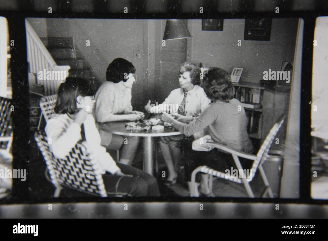 Belle photographie en noir et blanc vintage des années 1970 d'une fête de potins dans la cuisine. Banque D'Images