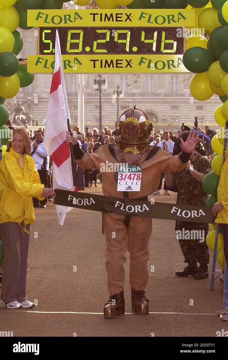 Lloyd Scott franchit la ligne d'arrivée du marathon de Londres, Lloyd, le coureur de marathan le plus lent de l'histoire, a 'couru' le parcours portant un costume de plongée antique en six jours.Lloyd espère avoir grandi dans la région de 100,000 en faveur du cancer et de la leucémie dans l'enfance grâce à ses efforts. Banque D'Images