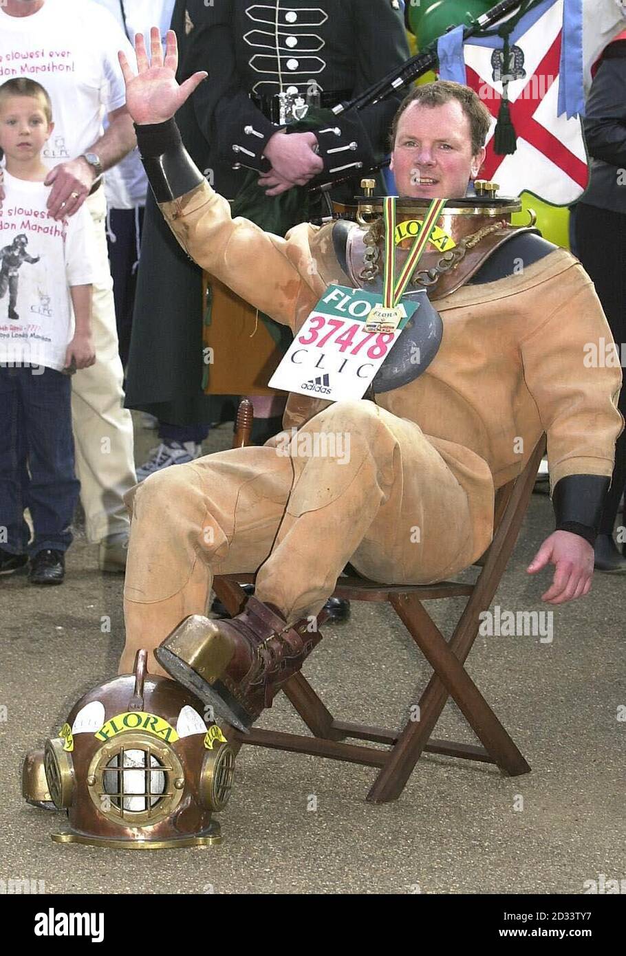Lloyd Scott se détend après avoir traversé la ligne d'arrivée du marathon de Londres, Lloyd, le coureur le plus lent de l'histoire, « a couru » le parcours portant un costume de plongée antique en six jours. Lloyd espère avoir grandi dans la région de 100,000 en faveur du cancer et de la leucémie dans l'enfance grâce à ses efforts. Banque D'Images