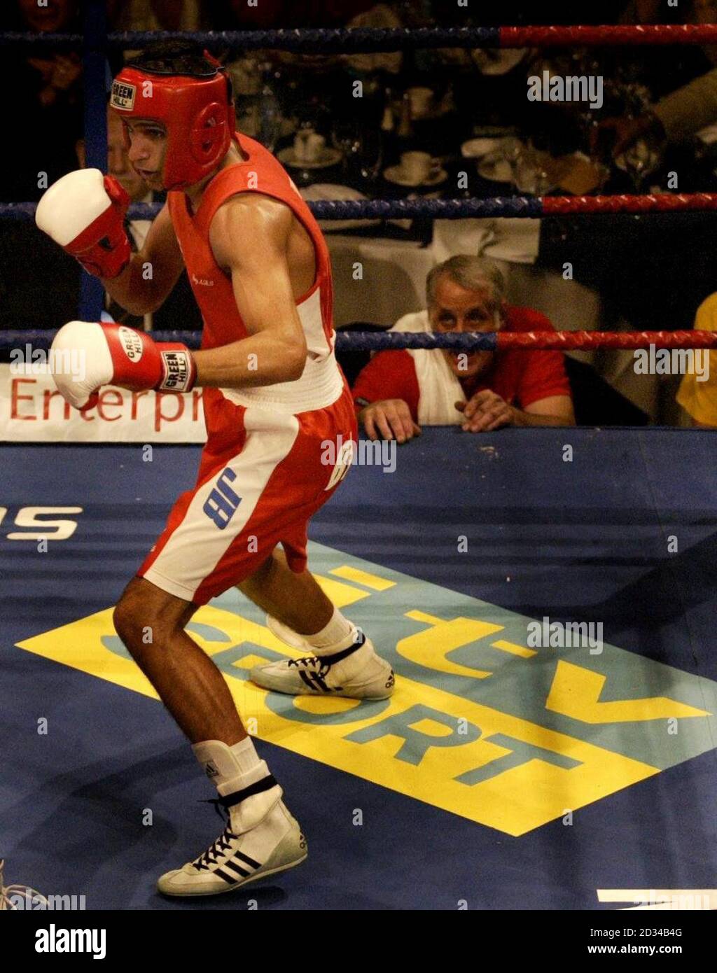 Amir Khan de Grande-Bretagne prend sa garde, sur le logo ITV Sport, contre Mario Kindelan de Cuba (non représenté) comme l'entraîneur Mick Jelly (en bas à droite) regarde pendant leur match de rempart. Banque D'Images Amir Khan de Grande-Bretagne prend sa garde, sur le logo ITV Sport, contre Mario Kindelan de Cuba (non représenté) comme l'entraîneur Mick Jelly (en bas à droite) regarde pendant leur match de rempart. Banque D'Images