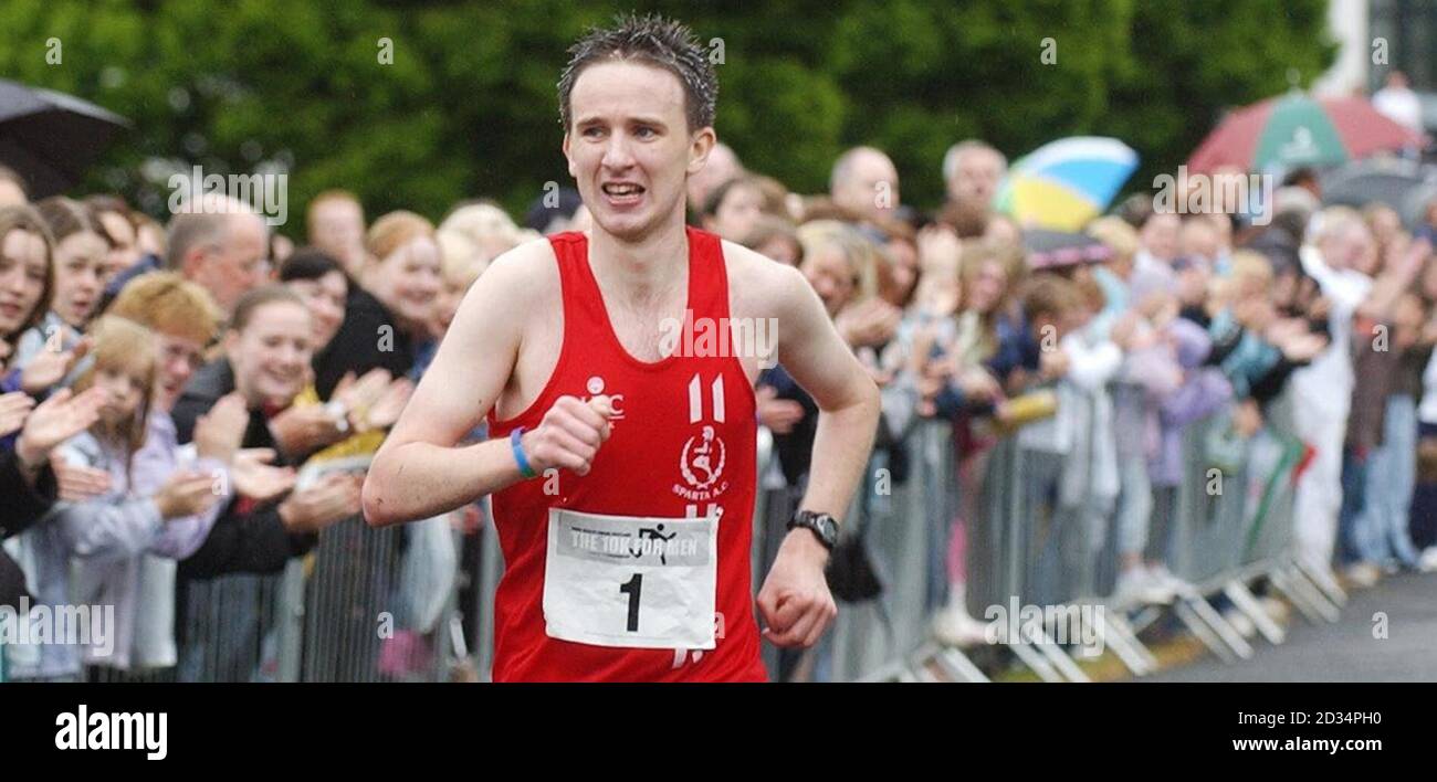 Seamus Kealey, vainqueur de la course, franchit la ligne d'arrivée du Men's Health Forum Scotland 10K course à Bellahouston Park à Glasgow. Banque D'Images