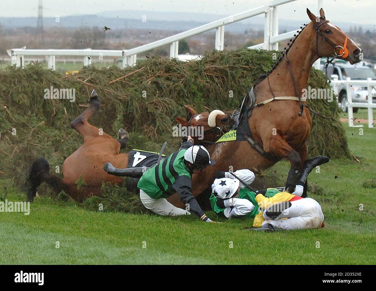 Des jockeys et des chevaux tombent au-dessus de la clôture de chaise pendant le totesport Becher Chase à l'hippodrome d'Aintree, Liverpool. Banque D'Images