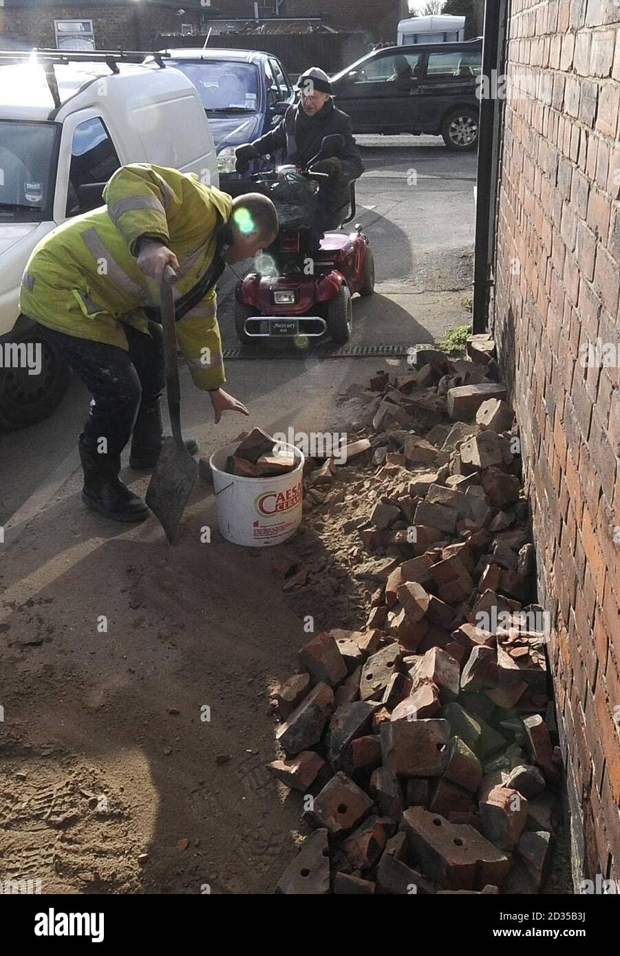 Les gravats d'une cheminée effondrée sont dévidés des trottoirs devant un plombier et des marchands de constructeurs à Selby aujourd'hui après le Quake de la Terre. Banque D'Images