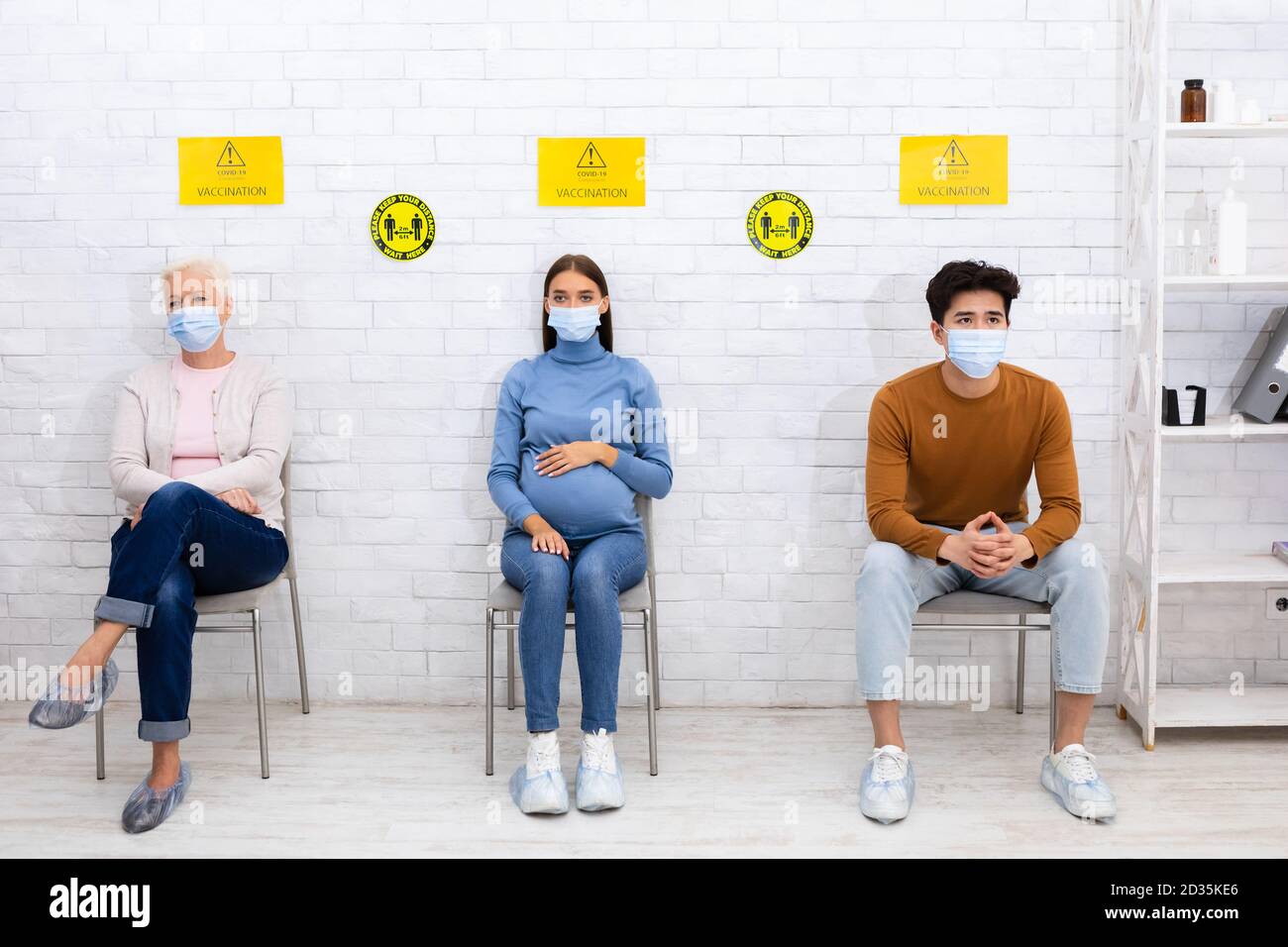 Patients en masques faciaux en attente de vaccination contre le coronavirus à l'hôpital Banque D'Images