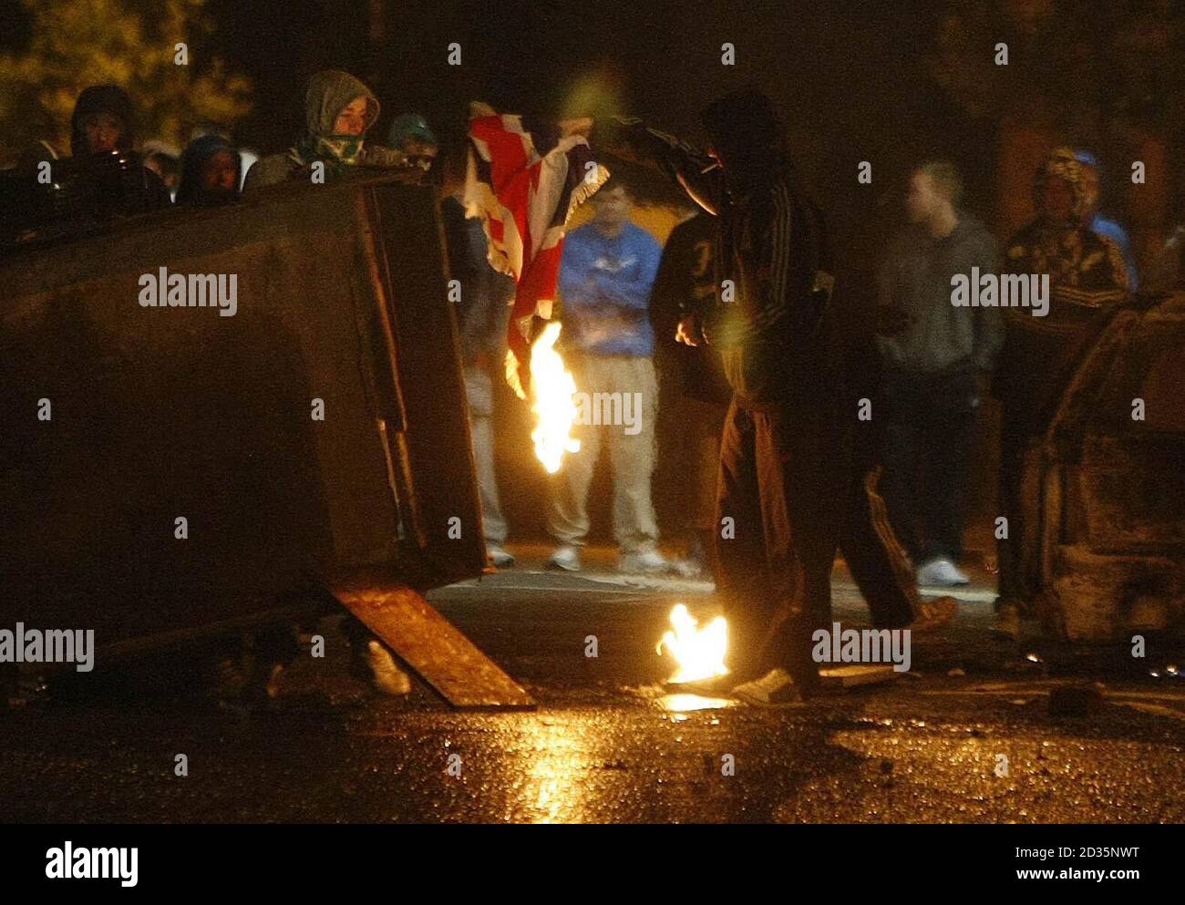 Un drapeau de l'Union est brûlé par des manifestants nationalistes dans la région d'Ardoyne Road, au nord de Belfast. Banque D'Images