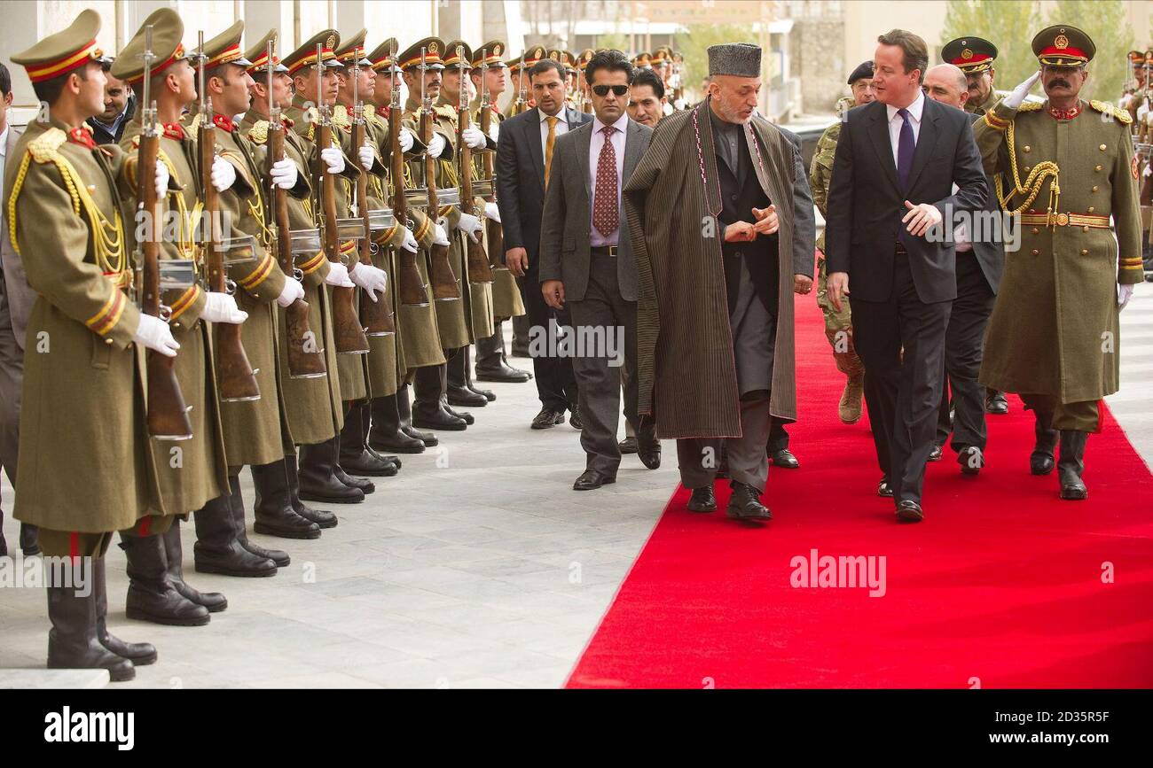 Le Premier ministre David Cameron (en avant à droite) et le président afghan Hamid Karzaï (en avant à gauche) passent une garde d'honneur avant leurs pourparlers à Kaboul, en Afghanistan. Banque D'Images