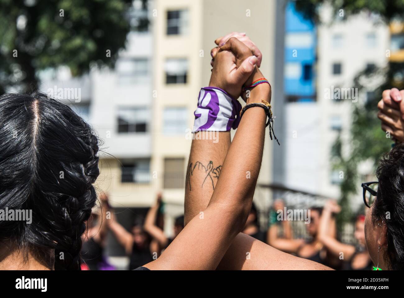 Les mains levées de 2 femmes de la «nous sommes groupe activiste de 2074' marchant et dansant dans les rues La solidarité à l'occasion de la Journée internationale des femmes 2020 Banque D'Images