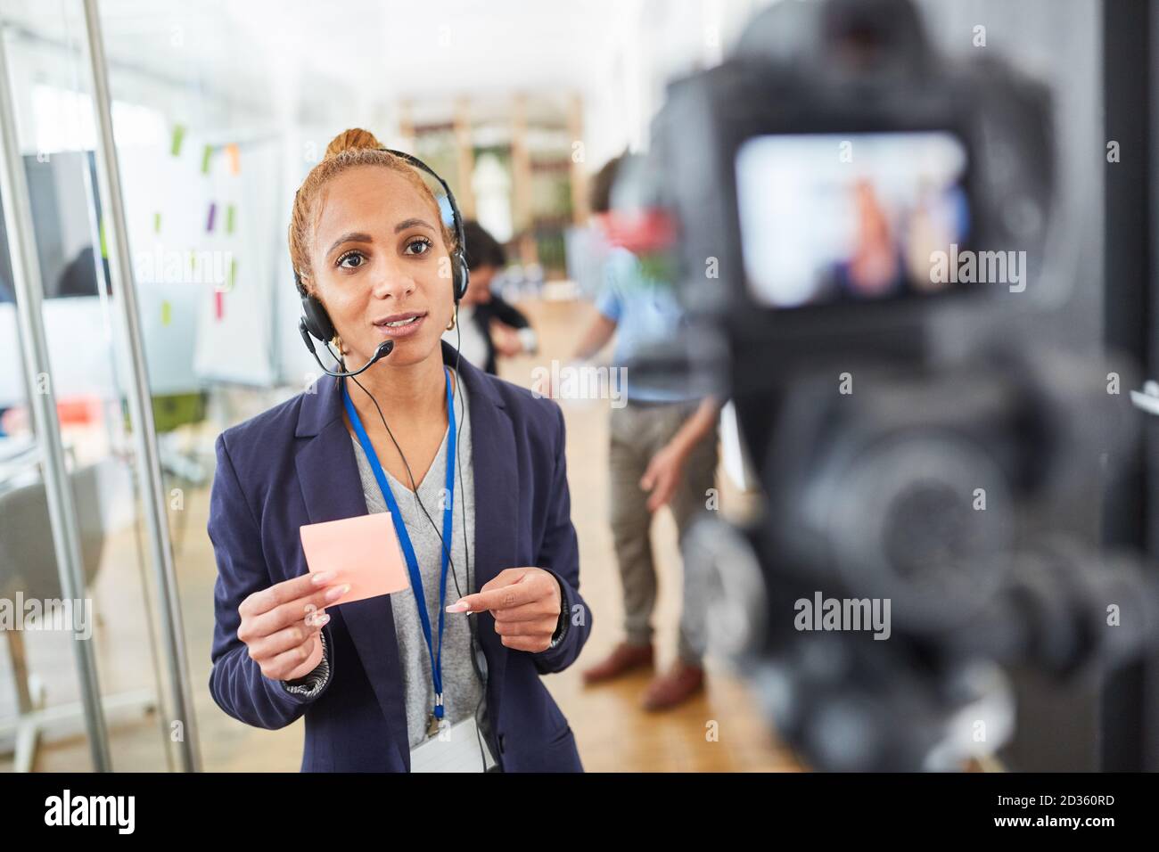 Femme d'affaires ou journaliste devant la caméra vidéo pendant un rapport actif Banque D'Images