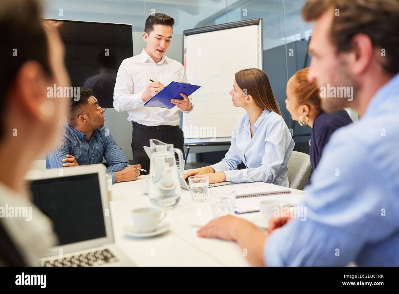 Homme d'affaires asiatique comme orateur avec liste de contrôle sur le presse-papiers dans atelier Banque D'Images