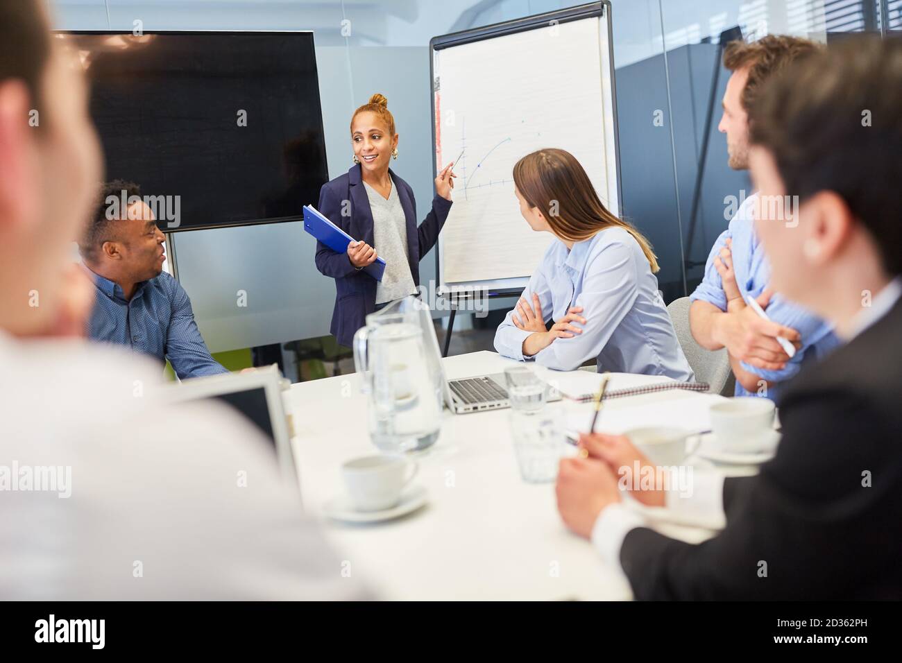 Jeune femme d'affaires donnant une présentation sur le tableau blanc dans l'atelier du projet Banque D'Images
