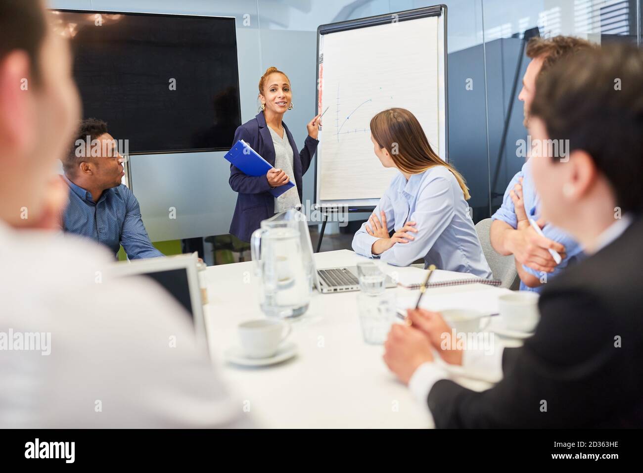 Jeune femme d'affaires dans l'atelier lors d'une présentation de projet sur le tableau Banque D'Images