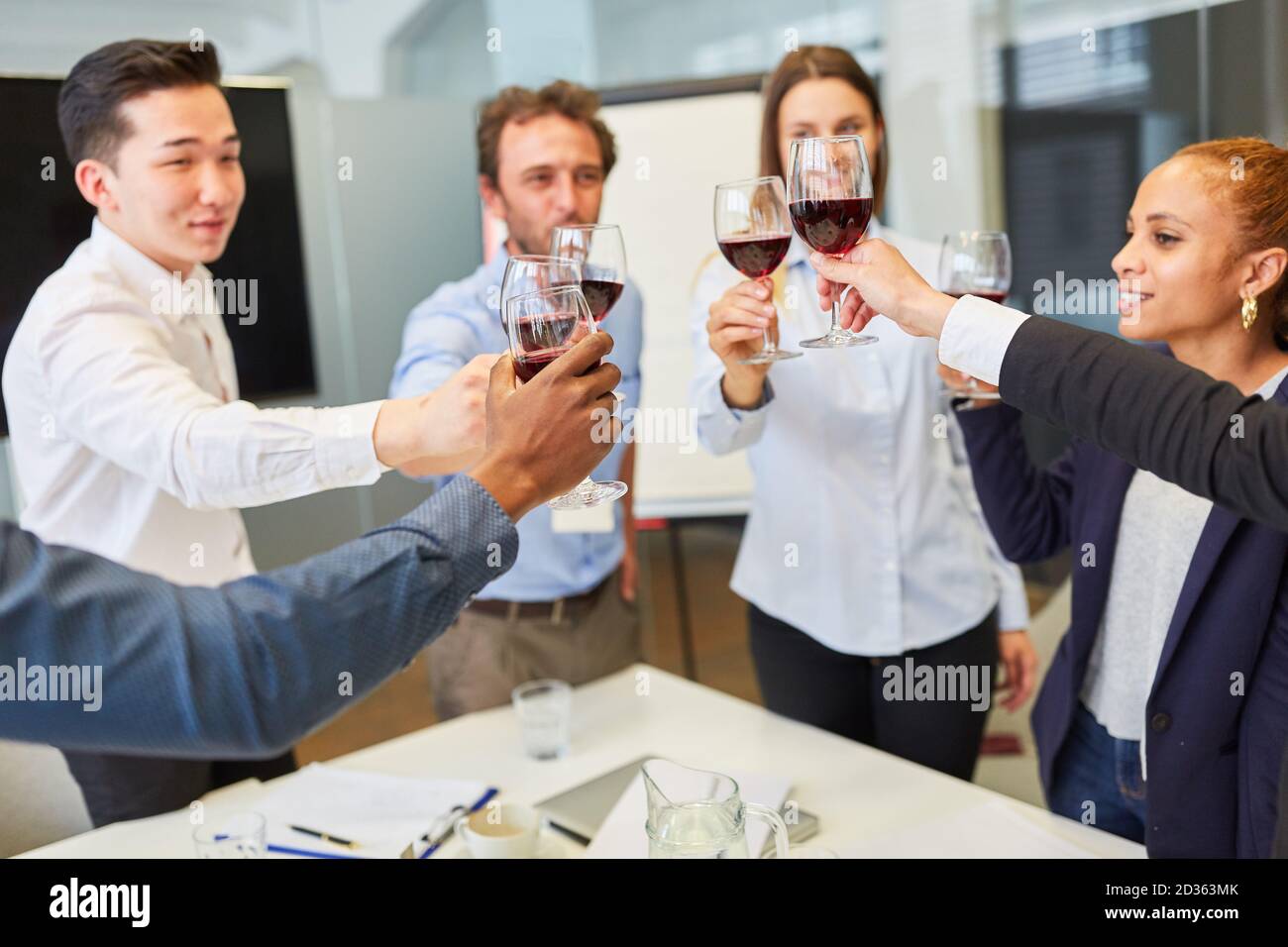 Jeunes gens d'affaires en démarrage qui célèbrent et toaster avec un verre de vin rouge Banque D'Images