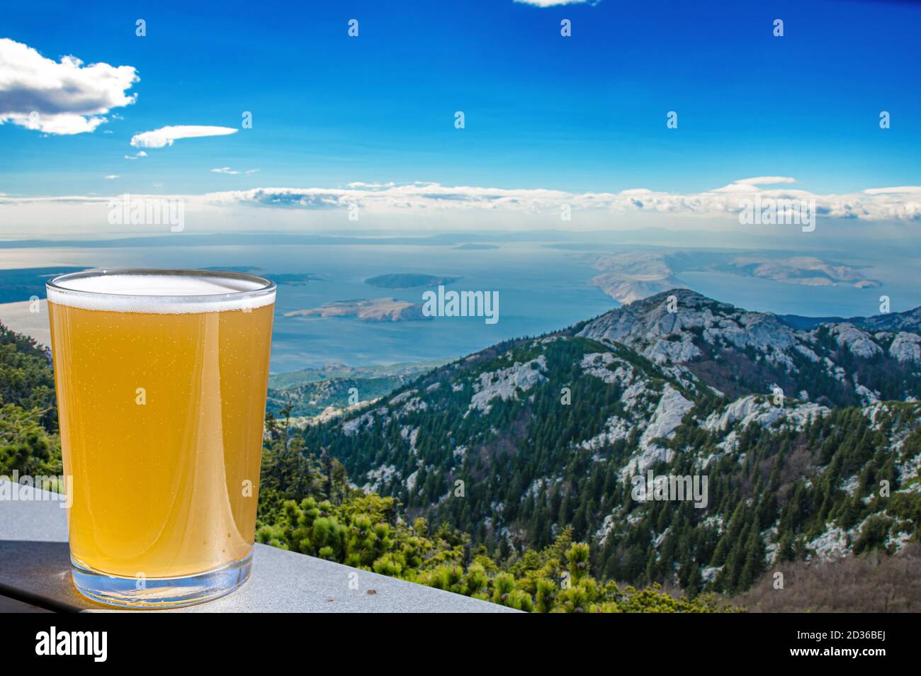 Verre de bière légère contre le magnifique paysage de montagne avec vue sur le bleu se dans les montagnes Velebit en Croatie. Banque D'Images