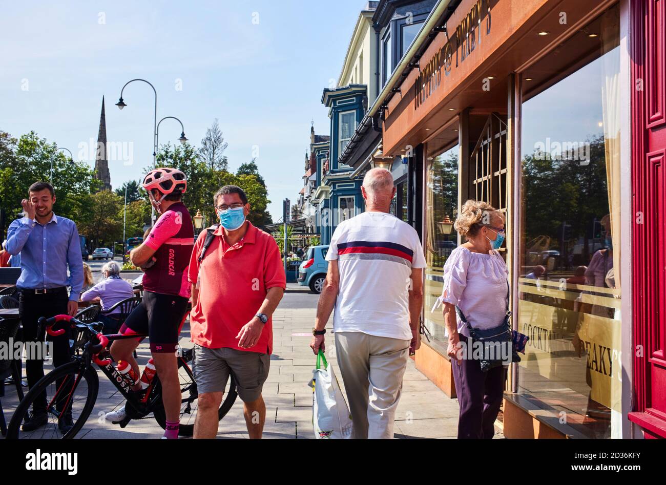 Les gens dans la rue commerçante principale de Southport certains portent le visage couvre certains sans Banque D'Images