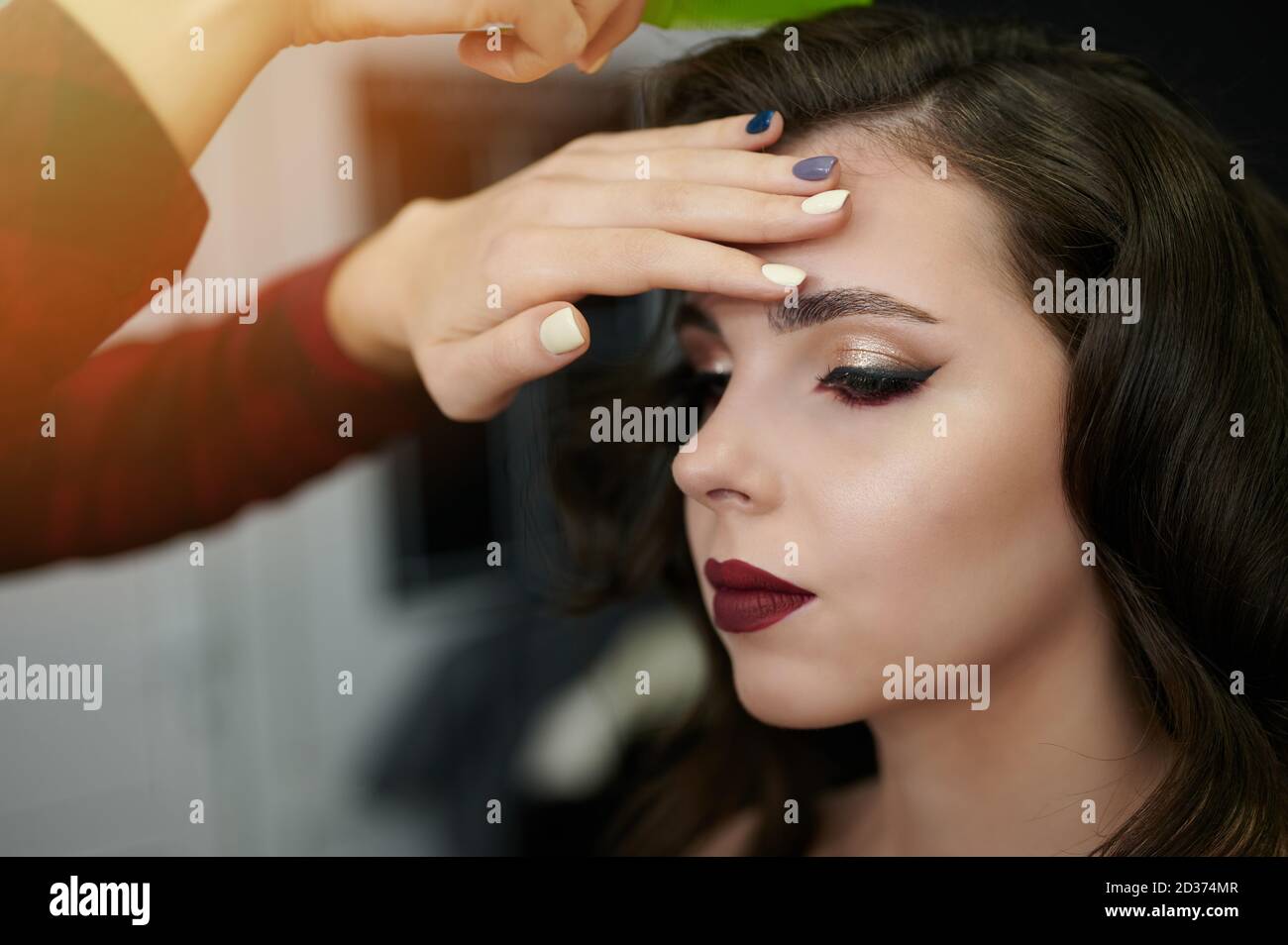 Coiffeur faisant un nouveau style pour la jeune femme en salon Banque D'Images