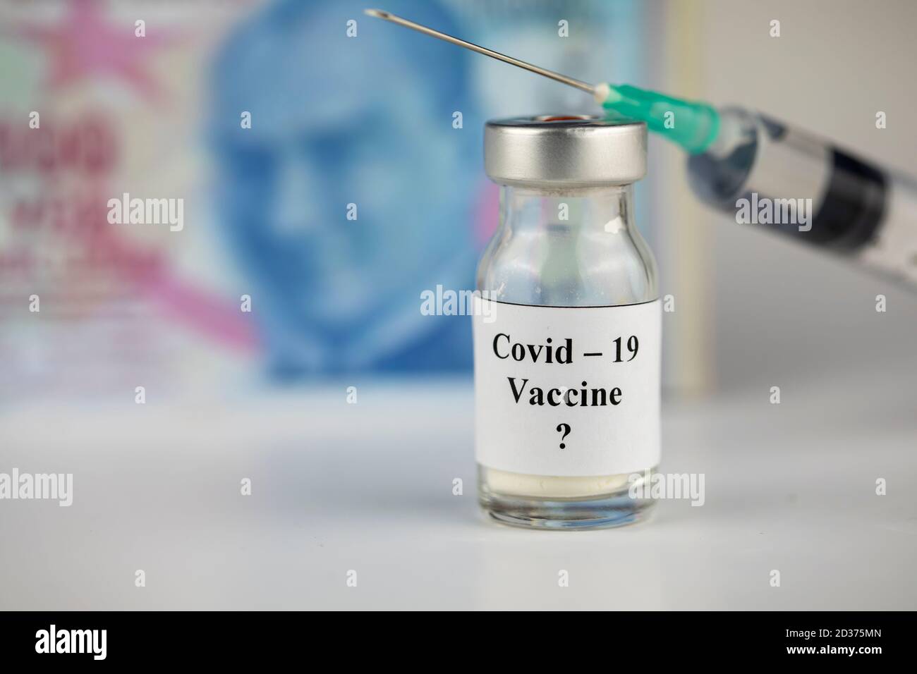 Le concept de pandémie et l'argent ( lire) à vacciner. Flacon de vaccin avec seringue pour Covid-19 Banque D'Images