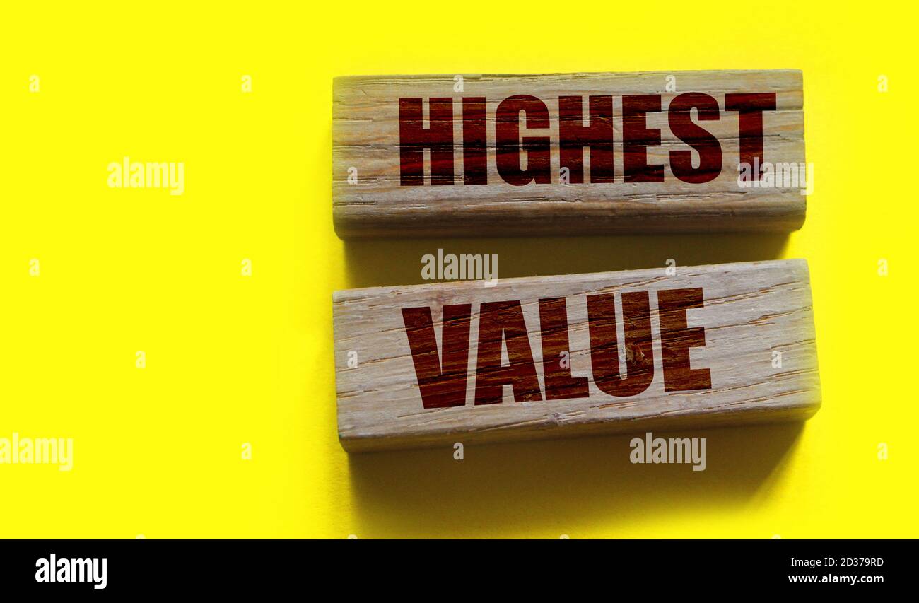 Mots de valeurs les plus élevées sur les blocs de construction en bois isolés sur jaune. Concept social, commercial et éducatif Banque D'Images