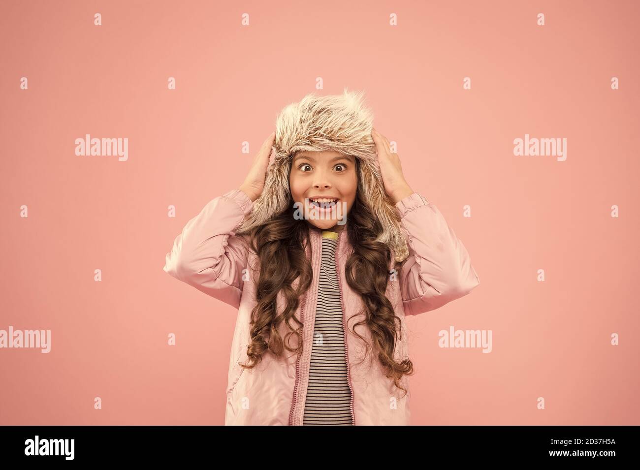 Vacances d'hiver. L'activité de la petite enfance. des vêtements chauds pour la saison froide. surpris enfant toile rose fashion kid.. trendy girl ressemblent à de la fourrure. hipster earflap hat accessoire. petite fille winter hat. Banque D'Images