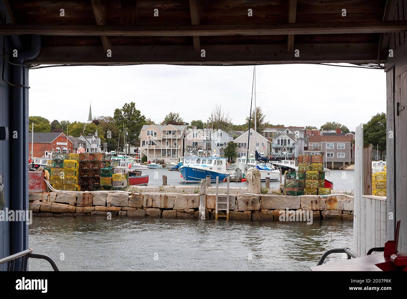 Quai/port/jetée de Rockport, Massachusetts, avec bateaux de pêche, voiliers et casiers à homard vus à travers une cabane de pêche en bois. Banque D'Images