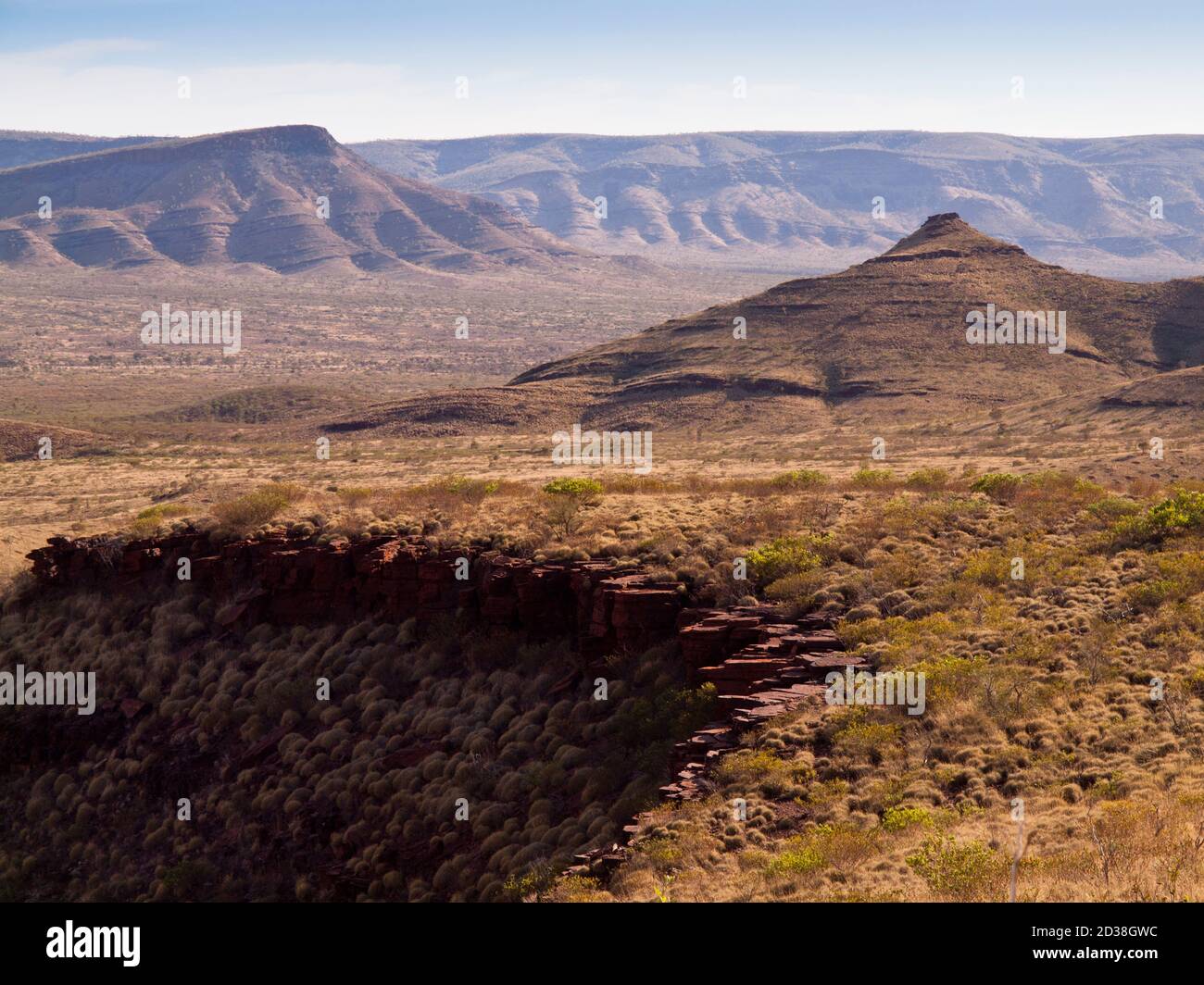 Montagnes érodées d'ironstone et plaines couvertes de spinifex, chaîne de Hamersley, parc national Karijini, Australie occidentale Banque D'Images