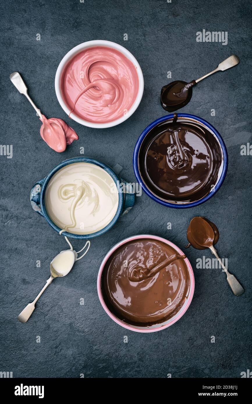 Quatre types de chocolat fondu dans des bols. Chocolat noir, chocolat au lait, chocolat blanc et chocolat rubis Banque D'Images