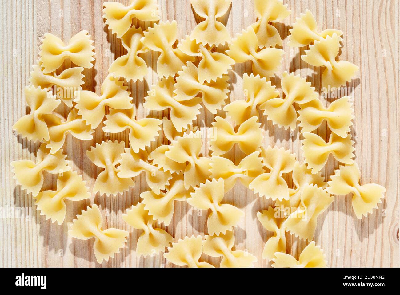 Pâtes sèches farfalle sur table en bois, pâtes papillon ou pâtes