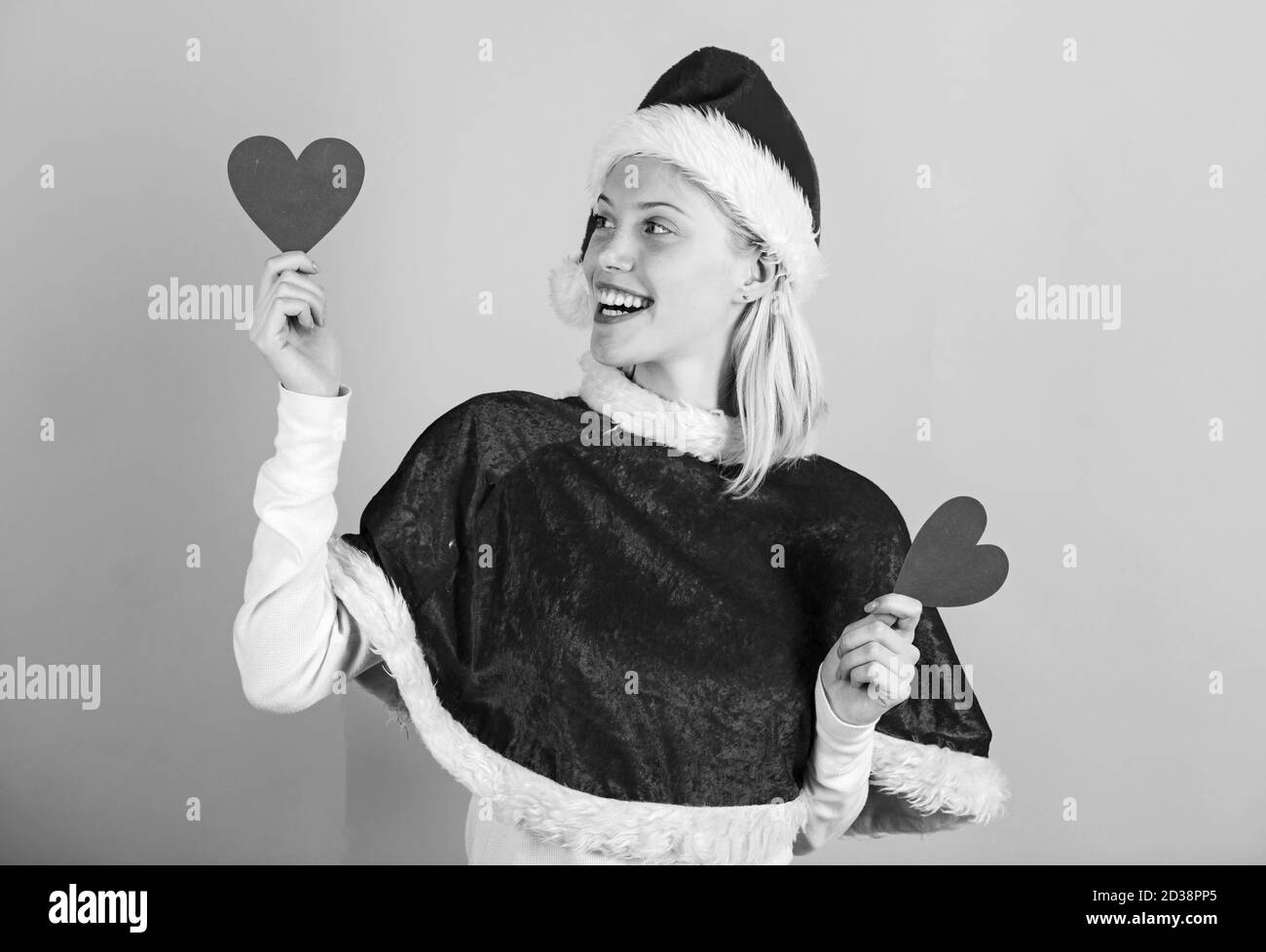 Apporter l'amour de vacances en famille. Répandre l'amour autour. Fille dans l'amour heureux porter costume père noël fêter Noël fond rose. Joyeux Noël et bonne année. Woman hold coeur symbole de l'amour. Banque D'Images