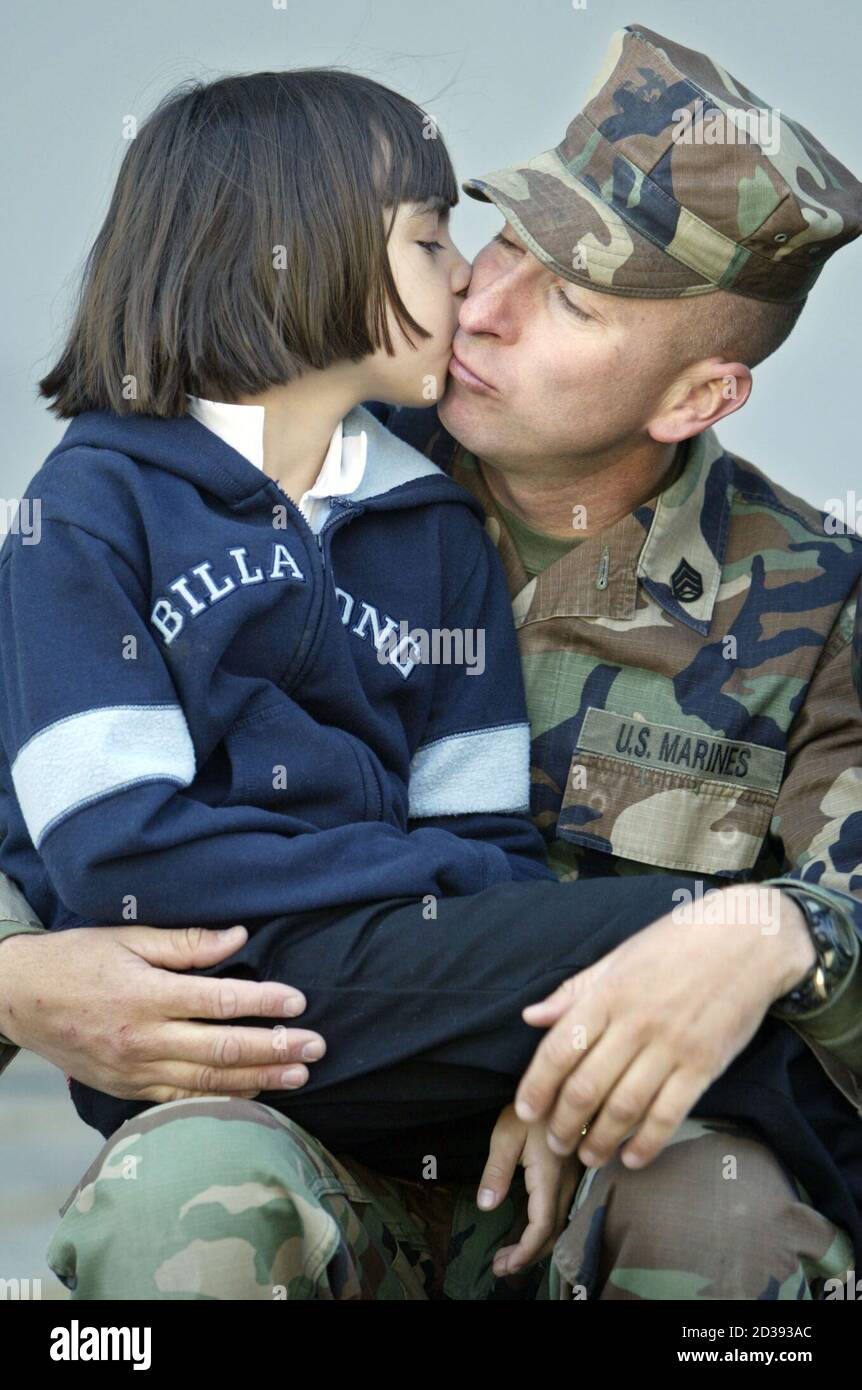 LE Sgt MARIN AMÉRICAIN José Salazar reçoit un baiser de Au revoir de sa fille bretonne de sept ans avant de partir sur l'USS Tarawa avec 4,000 autres marins et marins de la base navale de San Diego le 6 janvier 2002. L'USS Tarawa, l'USS Duluth et l'USS Rushmore se lancent dans une excursion régulière de six mois qui les emmènera dans le golfe Arabique ainsi que dans l'océan Indien et le Pacifique occidental. REUTERS/Fred Greaves FG/GAC Banque D'Images
