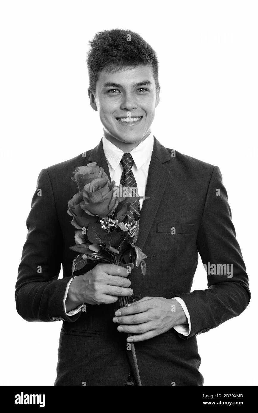 Young happy businessman smiling while holding roses rouges prête pour la Saint-Valentin Banque D'Images