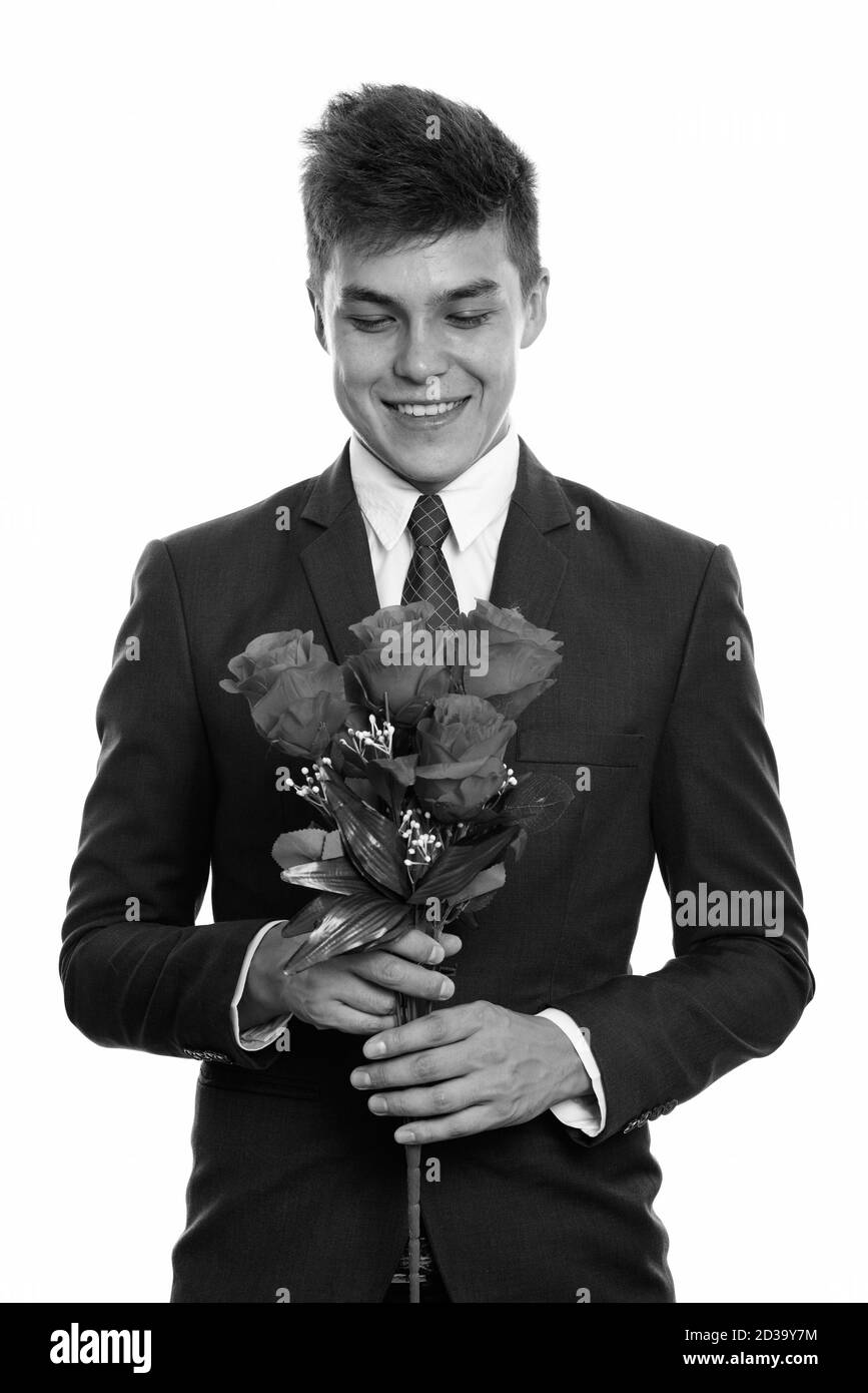 Young happy man tout en maintenant et en regardant les roses rouges prête pour la Saint-Valentin Banque D'Images