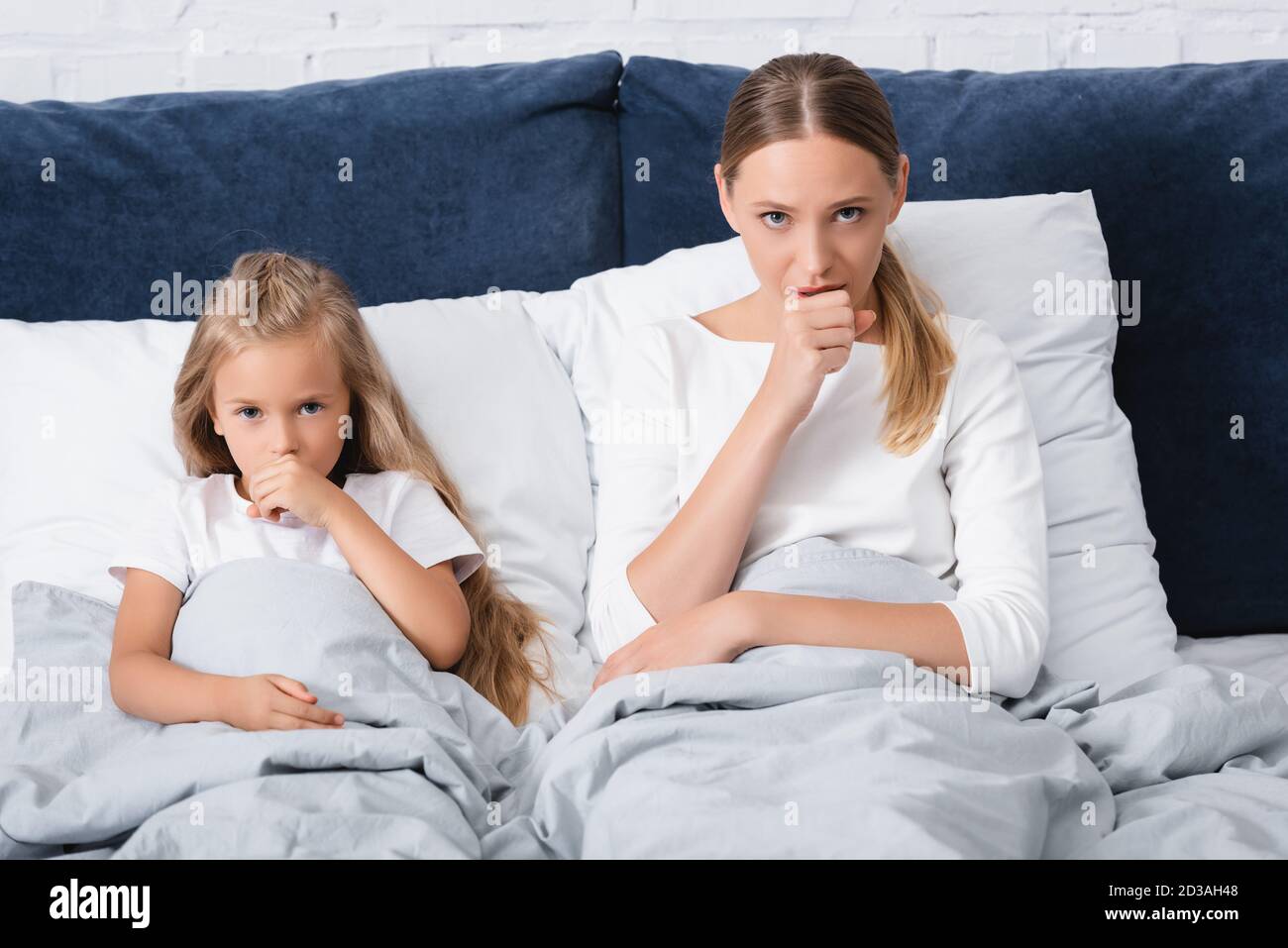 Concentration sélective de la toux de la mère et de l'enfant sur le lit à accueil Banque D'Images