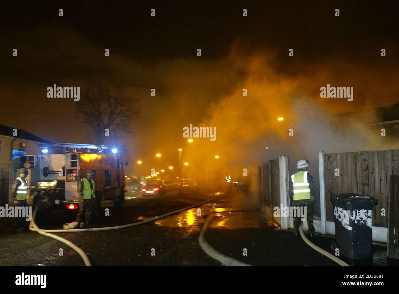 Le personnel de l'armée éteint un incendie de voiture avec des camions de pompiers de la Déesse verte à Manchester, lors d'une grève nationale des pompiers, le 14 novembre 2002. Les pompiers vont faire une grève nationale de 48 heures à compter du 13 novembre, après que leur syndicat a rejeté l'offre de 11 % de salaire. REUTERS/Ian Hodgson IH Banque D'Images
