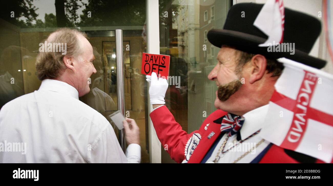 Executive Director of the English Football Association, David Davies (L) is  accosted and presented with a red card by protestor Ray Egan (R), dressed  as fictional English character John Bull, as he