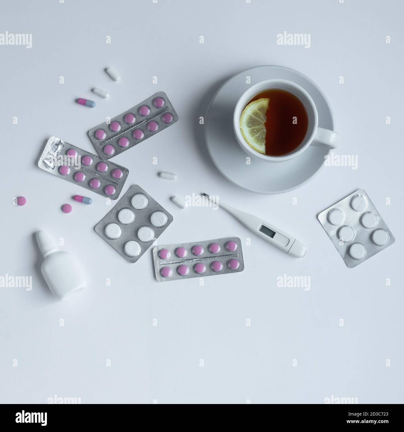 vue de dessus d'une tasse de thé, d'un thermomètre et de pilules sur fond blanc Banque D'Images
