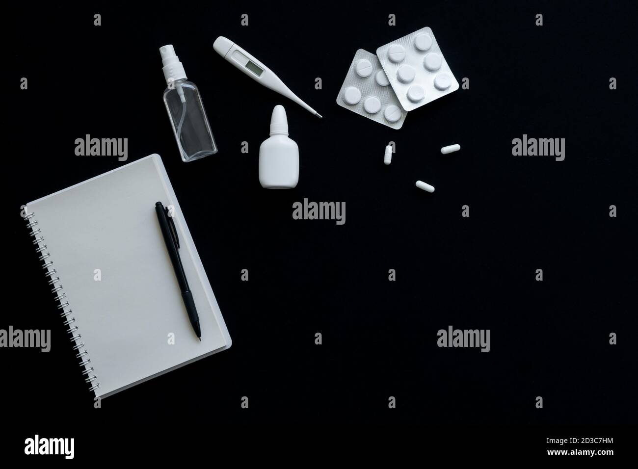 vue de dessus du thermomètre, des pilules et du carnet sur fond noir Banque D'Images