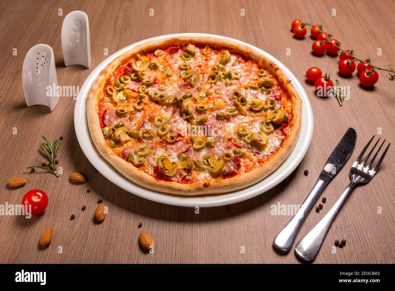 Gâteau mince à la pizza Capricciosa, tomate, olives, champignons, mozzarella, basilic Banque D'Images